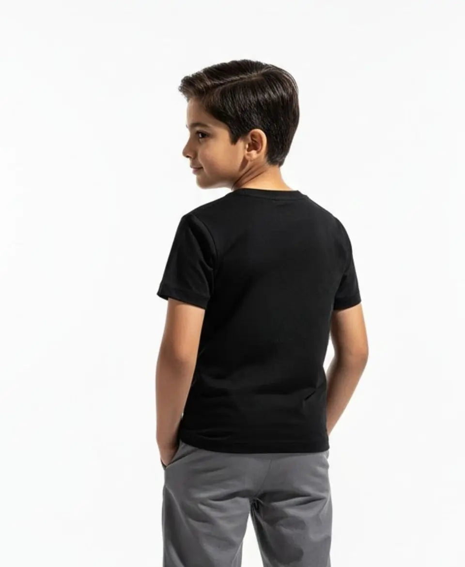 Child wearing a black t-shirt and gray pants on a white background