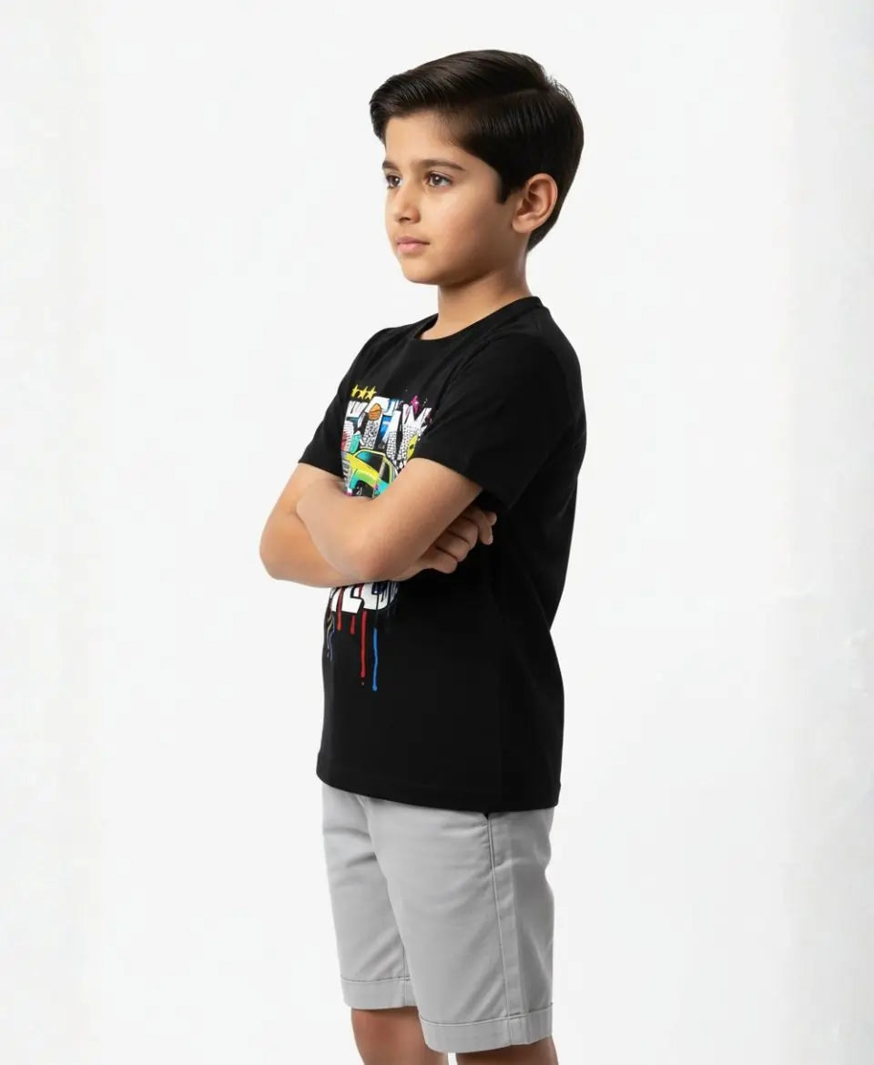 Child wearing a black t-shirt with colorful graphics and light gray shorts on a white background