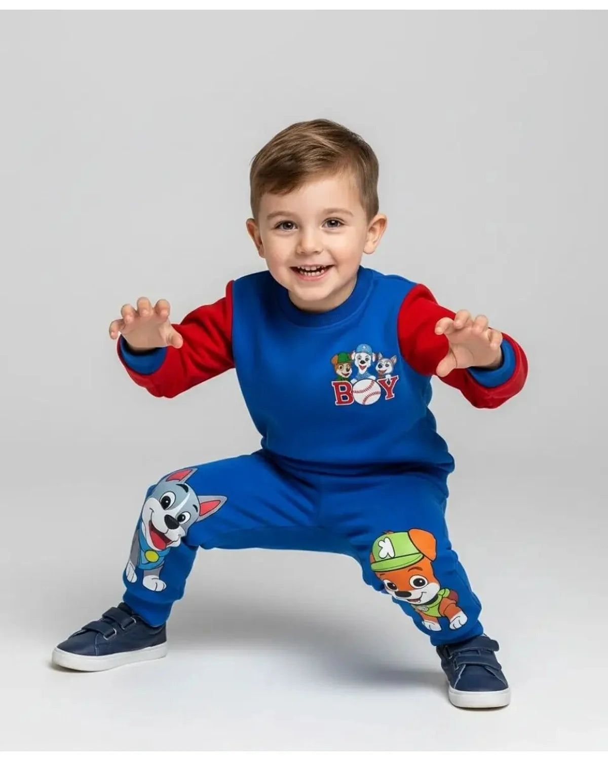 Child wearing a blue and red outfit with cartoon character design on a light gray background