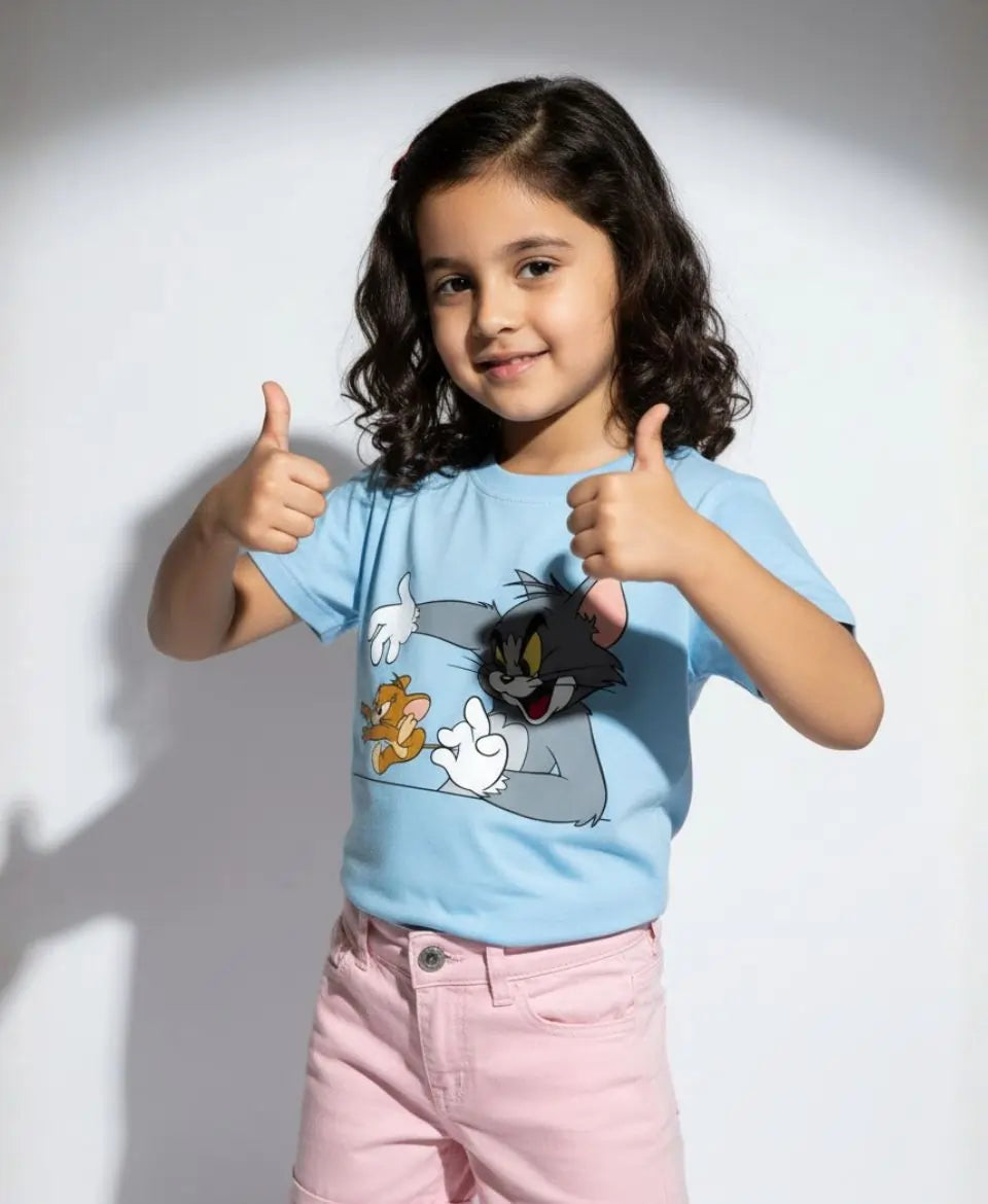 Child wearing a blue t-shirt with cartoon character design, giving thumbs up.