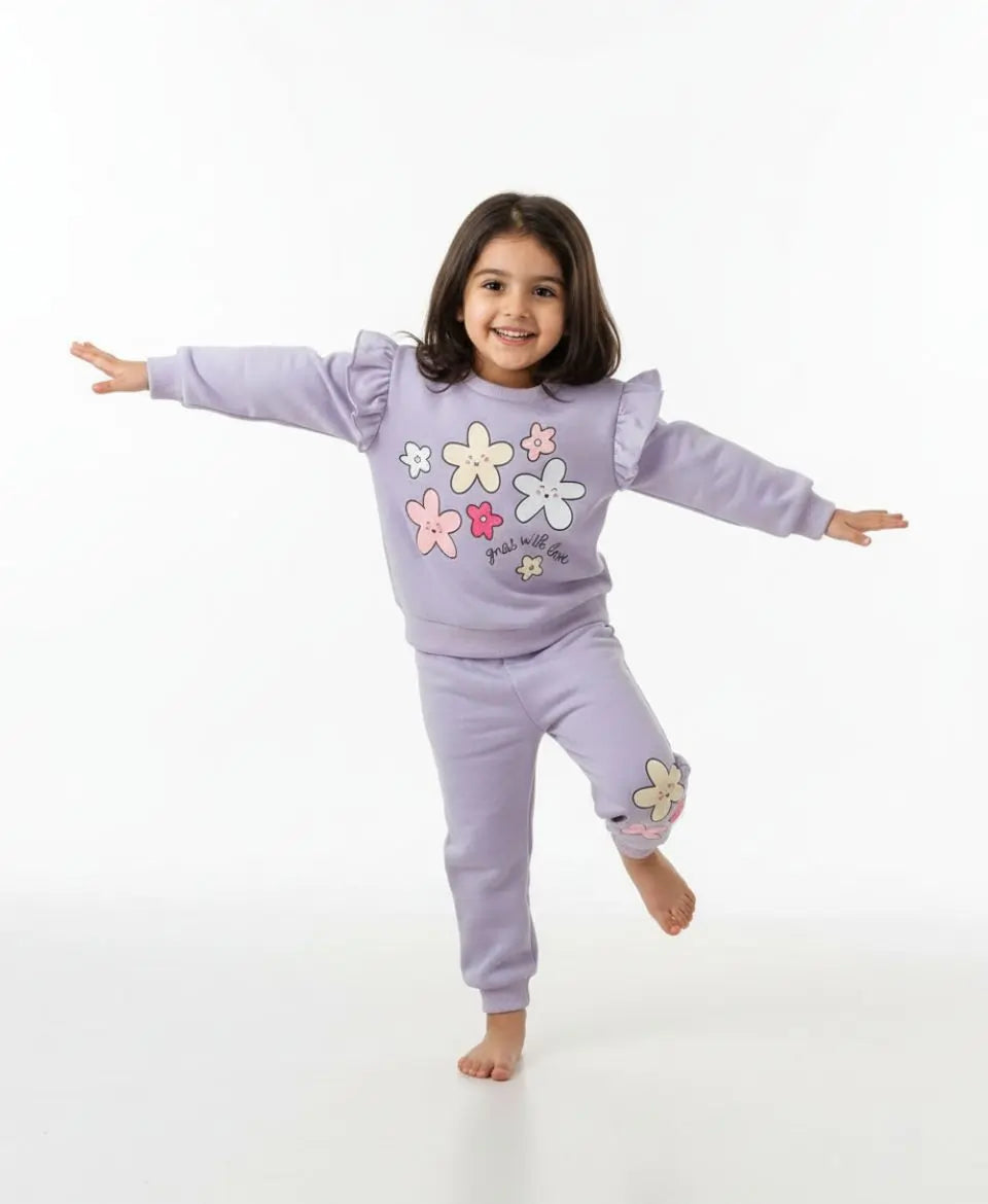 Child wearing a lavender outfit with floral designs on a white background