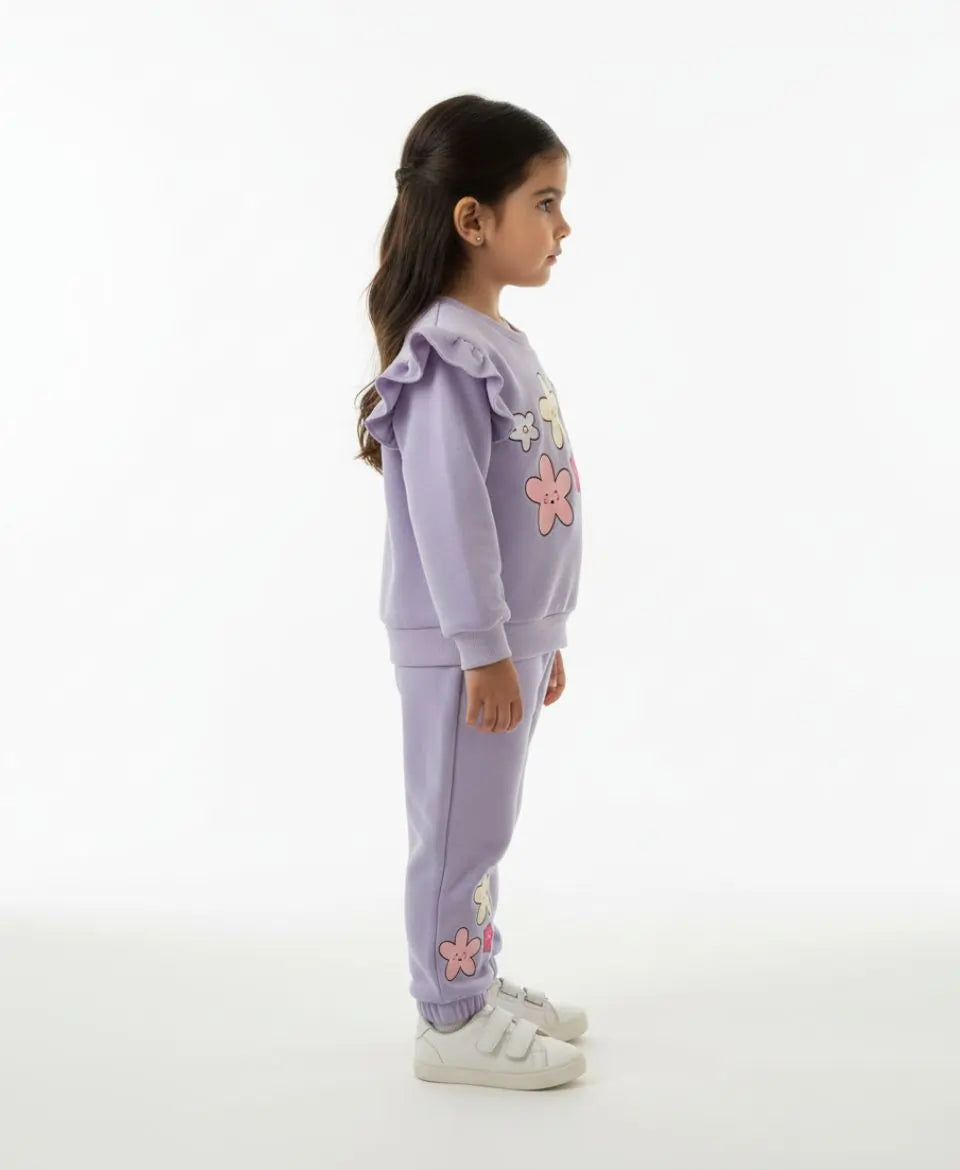 Child wearing a lavender tracksuit with floral designs on a white background