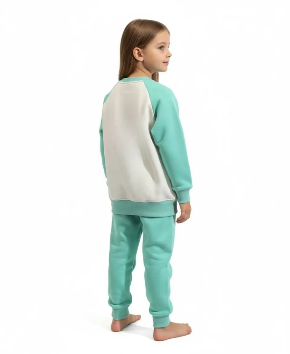 Child wearing a teal and white pajama set on a white background