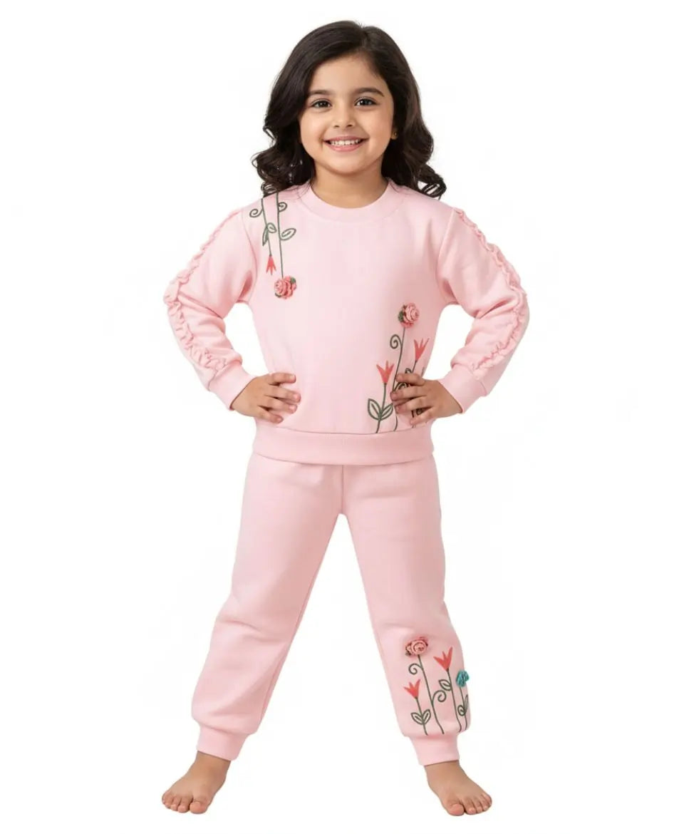 Young girl wearing a pink outfit with floral designs on a white background