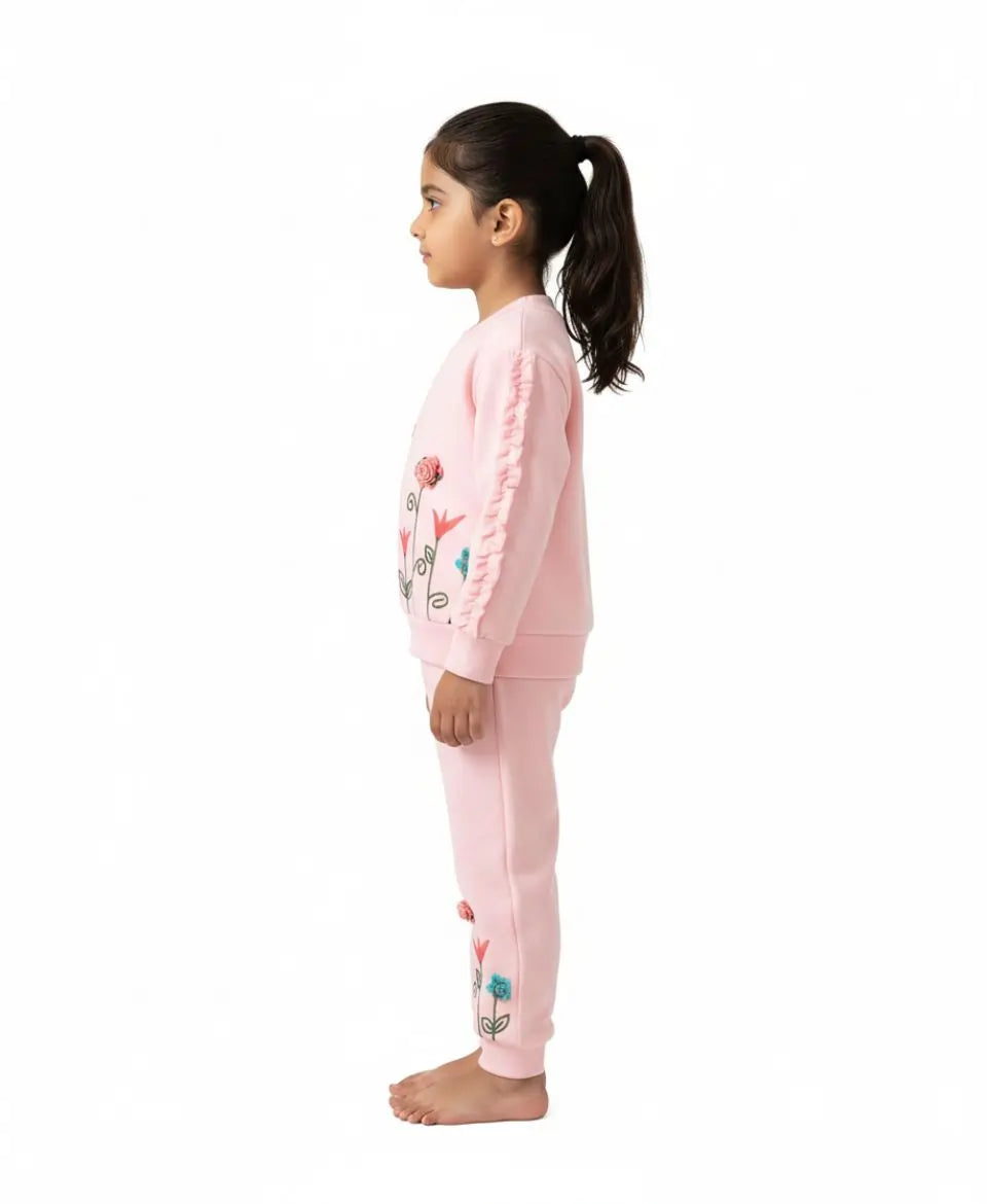 Young girl wearing a pink pajama set with floral designs on a white background