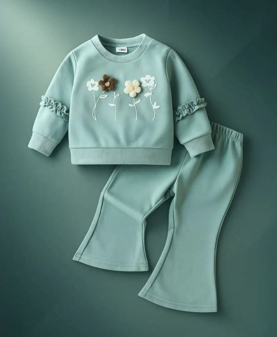 Light blue children's sweatshirt and pants set with floral embroidery on a green background