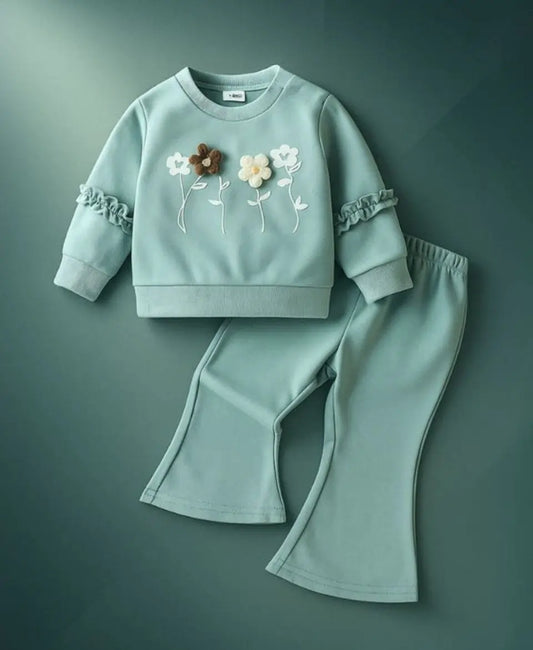 Light blue children's sweatshirt and pants set with floral embroidery on a green background
