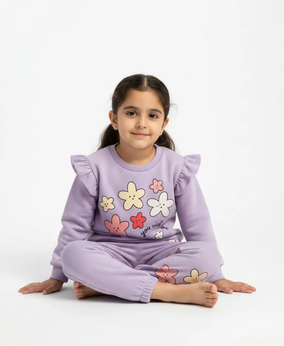 Young girl wearing a purple outfit with floral designs on a white background